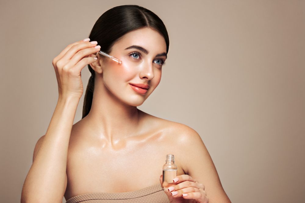 Kobieta nakłada na twarz naturalne serum z olejkami eterycznymi